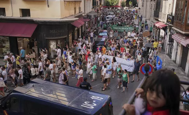 People march during a protest against overtourism in the Balearic island of Mallorca, Spain, Sunday, June 15, 2025. (AP Photo/Joan Mateu Parra)