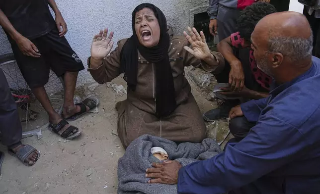 A Palestinian woman mourns over the body of her child killed in an Israeli military strike on Gaza, at Al-Shifa Hospital in Gaza City, Thursday, June 19, 2025. (AP Photo/Jehad Alshrafi)