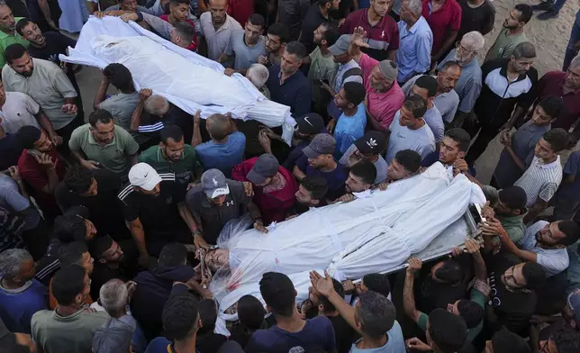 Palestinians carry the bodies of relatives who were killed in an Israeli military strike on Gaza, at Al-Shifa Hospital in Gaza City, Thursday, June 19, 2025. (AP Photo/Jehad Alshrafi)
