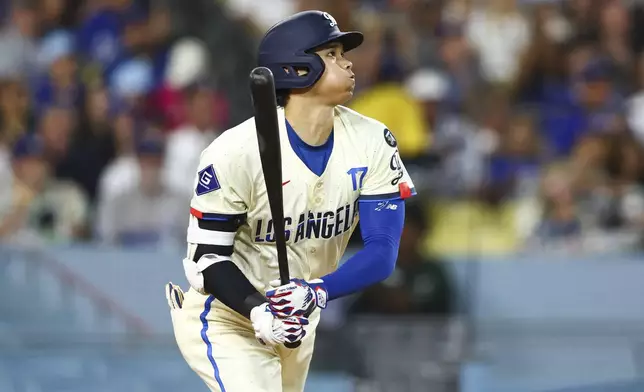 Los Angeles Dodgers designated hitter Shohei Ohtani follows through on a home run during the sixth inning of a baseball game against the San Francisco Giants in Los Angeles, Saturday, June 14, 2025. (AP Photo/Jessie Alcheh)