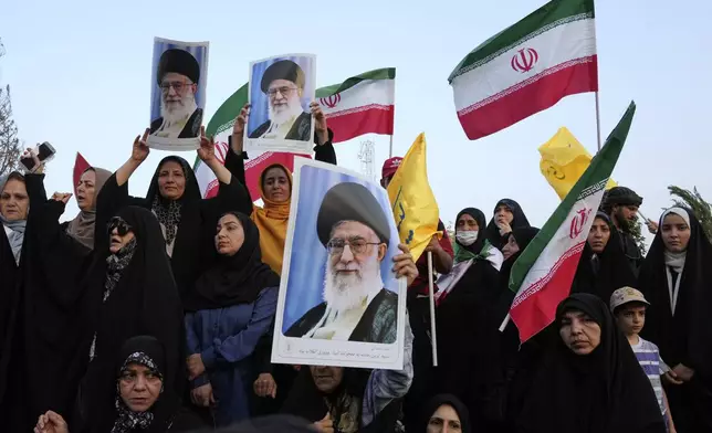 Iranian protesters hold their country's flags and posters of Supreme Leader Ayatollah Ali Khamenei in an anti-U.S. and anti-Israeli rally at Enqelab-e-Eslami (Islamic Revolution) square in downtown Tehran, Iran, Tuesday, June 24, 2025. (AP Photo/Vahid Salemi)