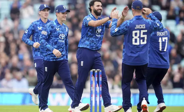 England's Saqib Mahmood, center left, celebrates the wicket of West Indies batter Shai Hope during the third One Day International cricket match between West Indies and England at Oval, London, Tuesday June 3, 2025. (Adam Davy/PA via AP)