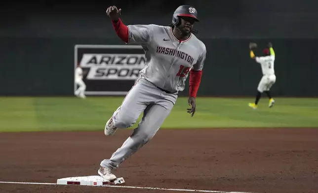 Washington Nationals' Josh Bell scores a run against the Arizona Diamondbacks on a double hit by WKeibert Ruiz in the first inning during a baseball game, Saturday, May 31, 2025, in Phoenix. (AP Photo/Rick Scuteri)