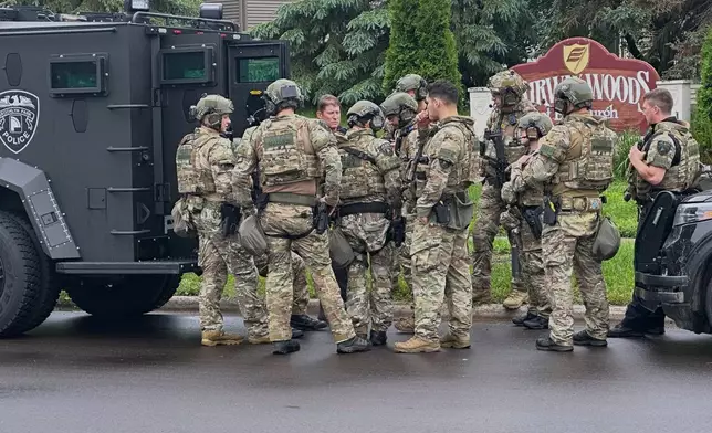 Police deploy as a manhunt is underway for a shooter that targeted two state lawmakers, in Brooklyn Park, Minn. on Saturday, June 14, 2025. (AP Photo/Tim Sullivan)