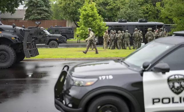 Law enforcement officers including local police, sheriffs and the FBI, stage less than a mile from a shooting in Brooklyn Park, Minn. on Saturday, June 14, 2025. (Alex Kormann/Star Tribune via AP)