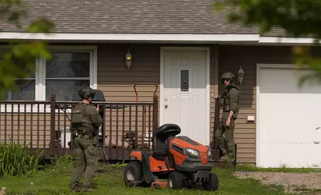 Members of law enforcement search for shooting suspect, Vance Boelter, at a house Sunday, June 15, 2025, in Belle Plaine, Minn. (AP Photo/George Walker IV)