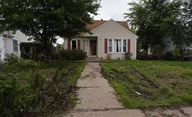 Tire marks from police vehicles mark the lawn of suspect Vance Luther Boelter's home in Minneapolis on Saturday, June 14, 2025. (AP Photo/Bruce Kluckhohn)