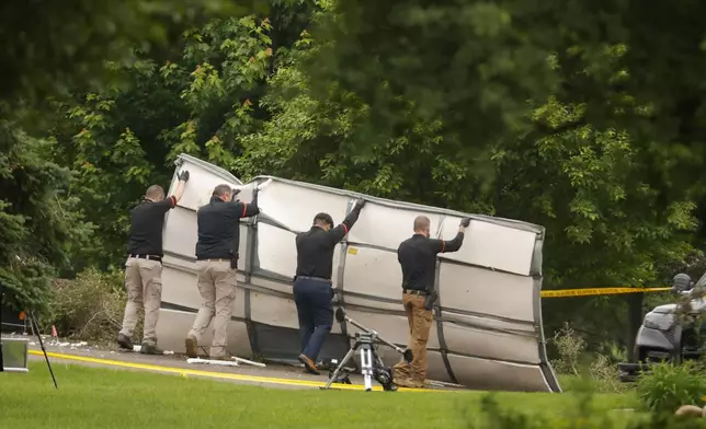 Investigators move debris from the home of Democratic former House Speaker Melissa Hortman and her husband, Mark, who were shot and killed earlier in the day, Saturday, June 14, 2025, in Brooklyn Park, Minn. (AP Photo/Bruce Kluckhohn)