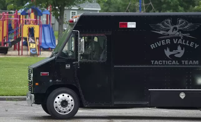 Law enforcement officers with the River Valley Tactical Team, prepare to visit the home of Vance Luther Boelter, who officials describe as a person of interest in the killing of Rep. Melissa Hortman and her husband, and the shooting of Sen. John Hoffman, near Green Isle, Minn., Saturday, June 14, 2025. (Anthony Souffle/Star Tribune via AP)
