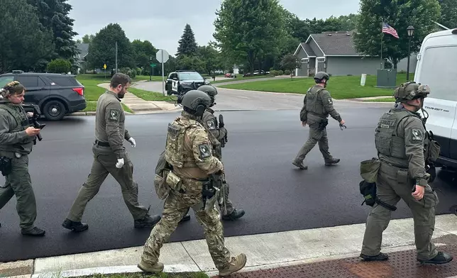Police deploy as a manhunt is underway for a shooter that targeted two state lawmakers, in Brooklyn Park, Minn. on Saturday, June 14, 2025. (AP Photo/Tim Sullivan)