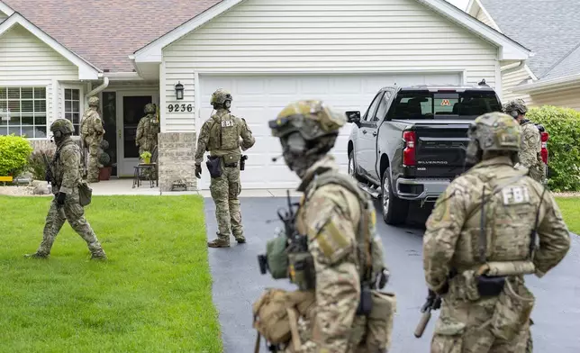 Armed FBI agents search for an active shooter, sweeping a neighborhood adjacent to the home of Minnesota DFL State Representative Melissa Hortman, in Brooklyn Park, Minn., Saturday, June 14, 2025. (Alex Kormann/Star Tribune via AP)