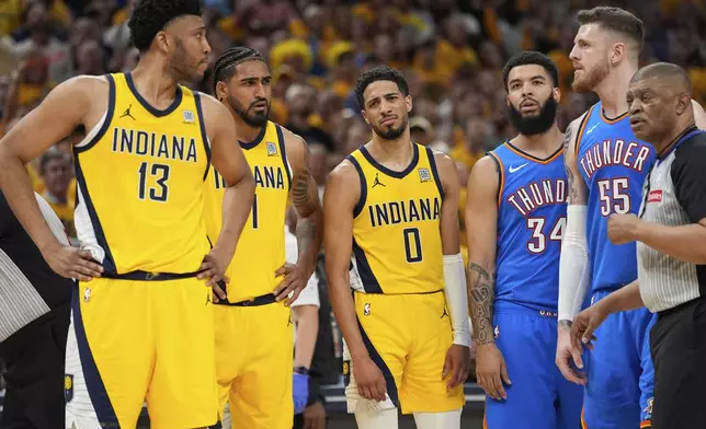 Indiana Pacers center Tony Bradley (13) looks towards Oklahoma City Thunder center Isaiah Hartenstein (55) after a foul as guard Tyrese Haliburton (0) looks toward Bradley during the second half of Game 6 of the NBA Finals basketball series, Thursday, June 19, 2025, in Indianapolis. (AP Photo/Abbie Parr)