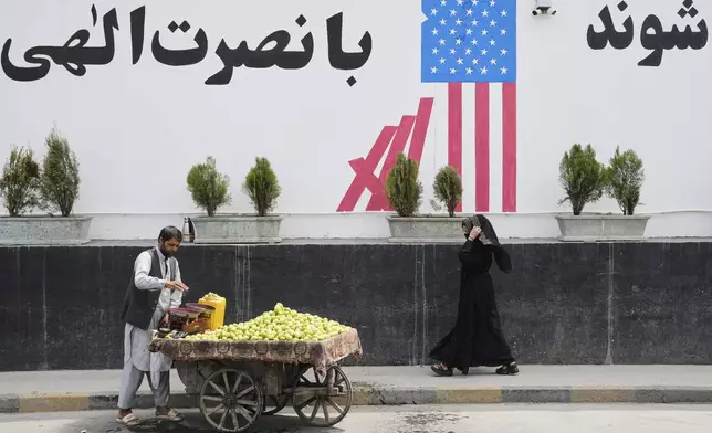 A vendor waits for customers in front of the former US embassy in Kabul, Afghanistan, Thursday, June 5, 2025. (AP Photo/Ebrahim Noroozi)