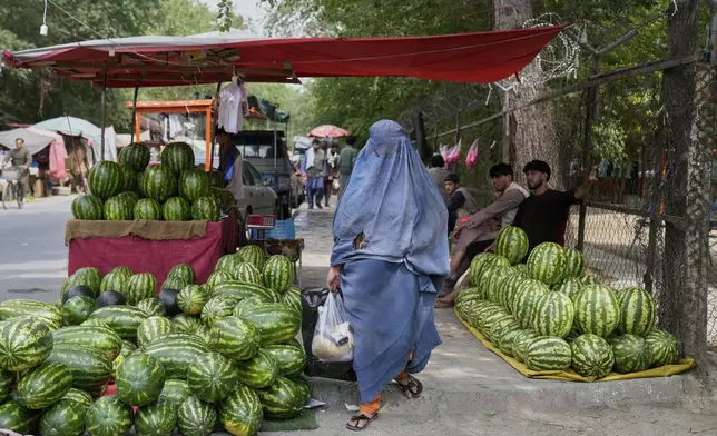 A woman shops in a market in Kabul, Afghanistan, Thursday, June 5, 2025. (AP Photo/Ebrahim Noroozi)