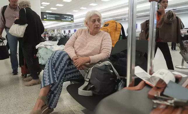 Mayra Cardenas waits for a friend before checking her bags on a flight back to Caracas, Venezuela, Thursday, June 5, 2025, at Miami International Airport. Cardenas was visiting her daughter in Orlando on a tourist visit. She fears she might not be able to see her family for many years. (AP Photo/Marta Lavandier)