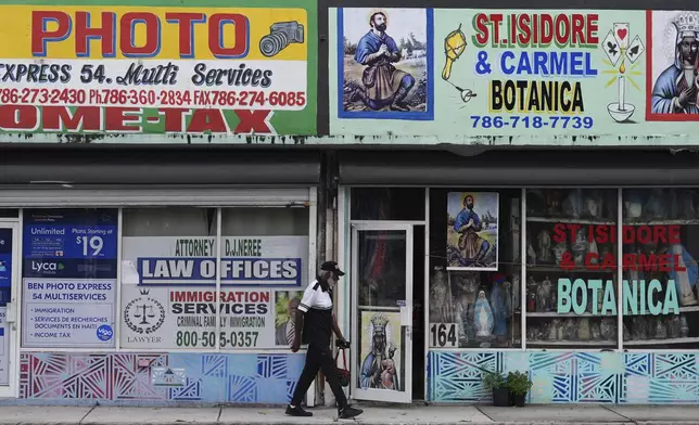 A man walks past businesses in Miami's Little Haiti neighborhood, Thursday, June 5, 2025. (AP Photo/Rebecca Blackwell)