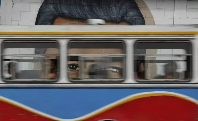 A public bus passes a mural of Venezuelan President Nicolas Maduro in Caracas, Venezuela, Thursday, June 5, 2025. (AP Photo/Ariana Cubillos)