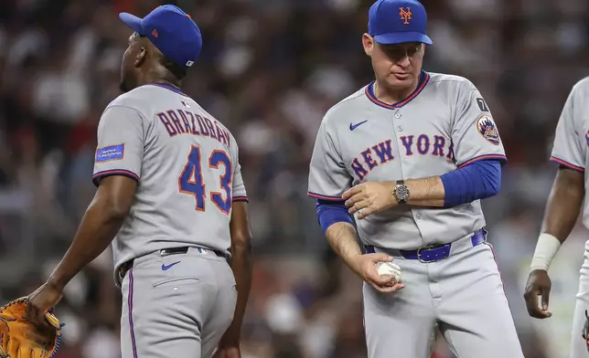 New York Mets manager Carlos Mendoza, right, relieves pitcher Huascar Brazobán (43) in the sixth inning of a baseball game against the Atlanta Braves, Thursday, June 19, 2025, in Atlanta. (AP Photo/Colin Hubbard)