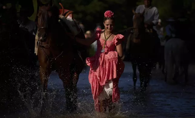 Pilgrims cross the Quema river near Aznalcázar, Spain, a crucial point in the annual Catholic pilgrimage to the shrine of the Virgin of El Rocio that draws hundreds of thousands of faithful, on June 5, 2025. (AP Photo/Emilio Morenatti)