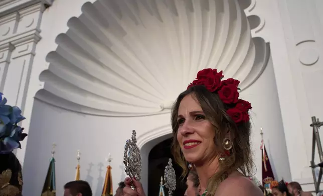 Pilgrims stand next to the shrine of El Rocio near Aznalcázar, Spain, on Saturday June 7, 2025, during the annual pilgrimage in which hundreds of thousands of devotees of the Virgin del Rocio converge in and around the shrine. (AP Photo/Emilio Morenatti)
