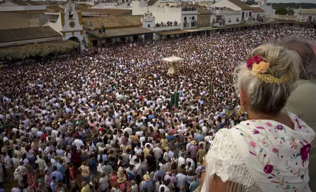 Pilgrims carry the Virgin of El Rocio during a procession in the village of El Rocio, near Almonte in southern Spain, on June 9, 2025, during the annual pilgrimage in which hundreds of thousands of devotees of the Virgin del Rocio converge in and around the shrine. (AP Photo/Emilio Morenatti)