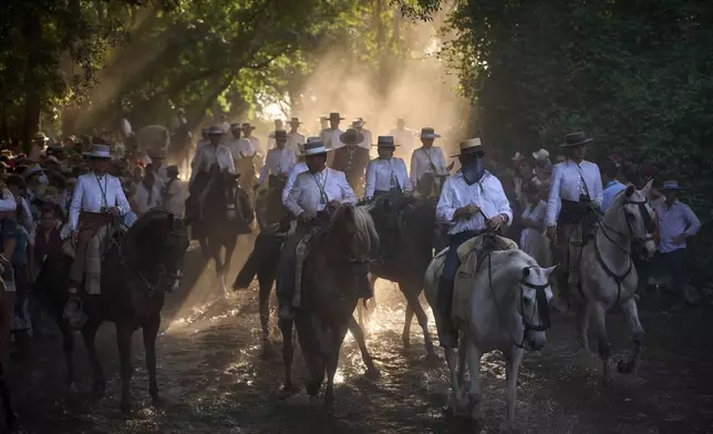 Pilgrims ride horses near Aznalcázar, Spain, during the annual Catholic pilgrimage to the shrine of the Virgin of El Rocio, that draws hundreds of thousands of faithful, on June 6, 2025. (AP Photo/Emilio Morenatti)