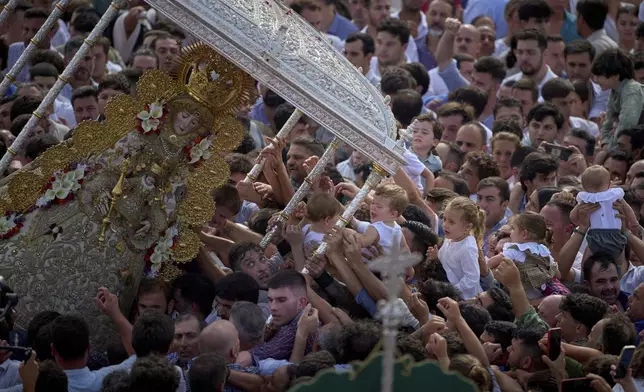 Pilgrims carry the Virgin of El Rocio during a procession in the village of El Rocio, near Almonte in southern Spain, on June 9, 2025, during the annual pilgrimage in which hundreds of thousands of devotees of the Virgin del Rocio converge in and around the shrine. (AP Photo/Emilio Morenatti)
