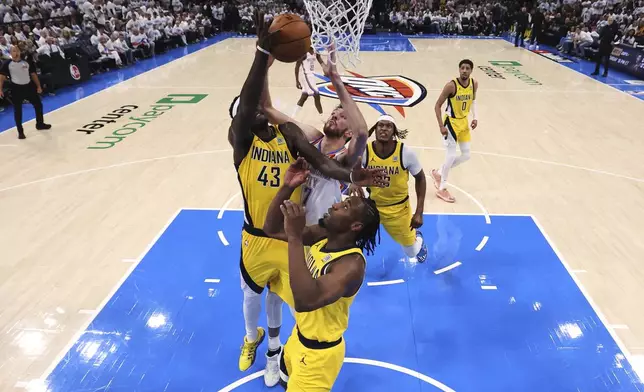 Oklahoma City Thunder forward Chet Holmgren (7), Indiana Pacers forward Pascal Siakam (43) and forward Aaron Nesmith (23) reach for the ball during Game 1 of the NBA Finals basketball series Thursday, June 5, 2025, in Oklahoma City. (Matthew Stockman/Pool Photo via AP)
