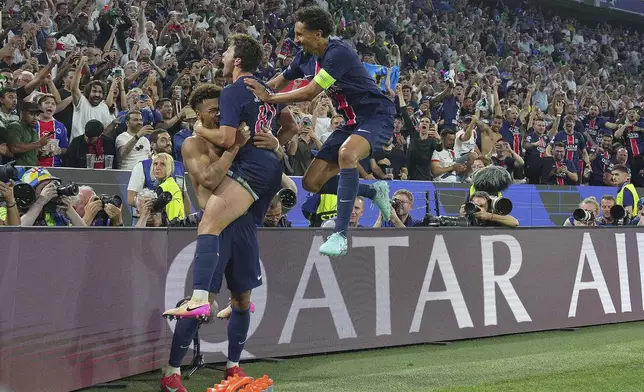 PSG's Desire Doue, left, celebrates with teammates after scoring during the Champions League Final soccer match between Paris Saint Germain and Inter at the Allianz Arena in Munich, Germany, Saturday May 31, 2025 . (Spada/LaPresse via AP)
