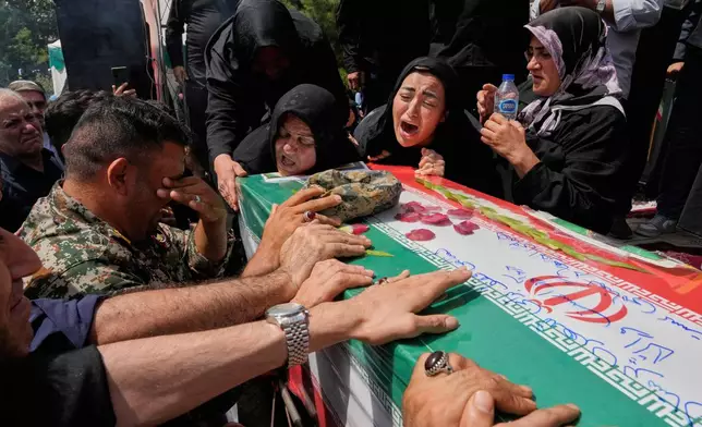 Relatives mourn over the flag-draped coffin of Mahan Setareh, a member of the paramilitary Basij force who was killed in Israeli attacks, during his funeral ceremony in Tehran, Iran, Thursday, June 26, 2025. (AP Photo/Vahid Salemi)