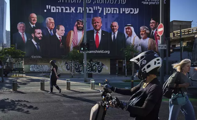 An electronic billboard beams an image of US President Donald Trump and Mideast leaders with a Hebrew message that reads "A time for waging war and a time for reaching a settlement. Now is the time for the 'covenant of Abraham," in Tel Aviv, Israel, on Thursday, June 26, 2025. (AP Photo/Oded Balilty)