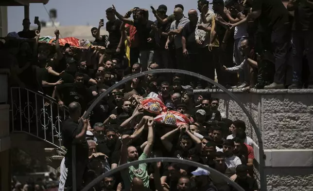 Mourners carry the bodies of three Palestinians who were killed on Wednesday when Jewish settlers stormed the West Bank village of Kafr Malik, Thursday, June 26, 2025. (AP Photo/Leo Correa)