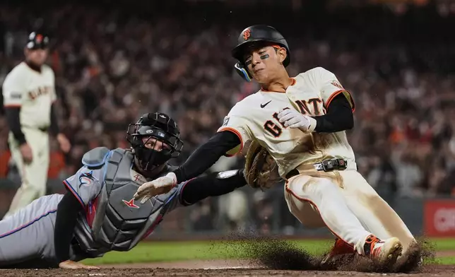 San Francisco Giants' Jung Hoo Lee, right, is tagged out at home by Miami Marlins catcher Nick Fortes to end the ninth inning of a baseball game Wednesday, June 25, 2025, in San Francisco. (AP Photo/Godofredo A. Vásquez)