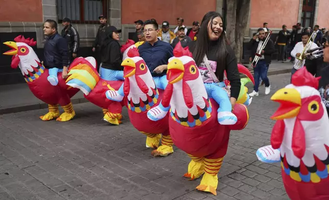 People wearing rooster costumes protest against laws that ban animal blood sports like cockfighting and bullfighting in Mexico City, Thursday, June 26, 2025. (AP Photo/Eduardo Verdugo)
