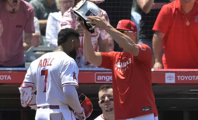 Los Angeles Angels' Jo Adell (7) is greeted at the dugout by Angels' Logan O'Hoppe after a solo home run in the fourth inning of a baseball game against the Boston Red Sox, Wednesday, June 25, 2025, in Anaheim, Calif. (AP Photo/Jayne Kamin-Oncea)