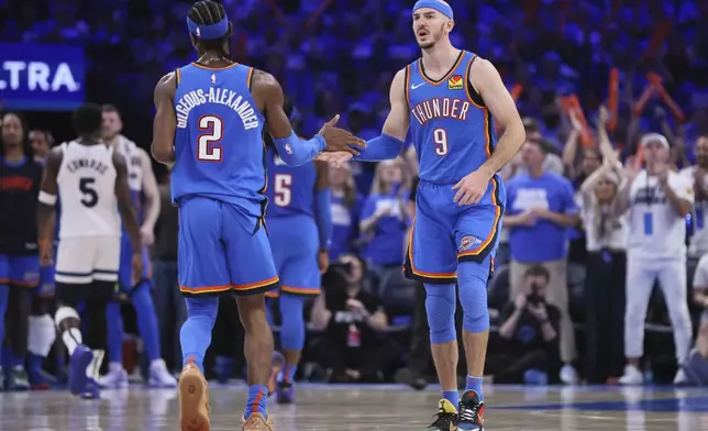 Oklahoma City Thunder guards Shai Gilgeous-Alexander (2) and Alex Caruso (9) high-five during the second half of Game 5 of the Western Conference finals of the NBA basketball playoffs against the Minnesota Timberwolves, Wednesday, May 28, 2025, in Oklahoma City. (AP Photo/Nate Billings)