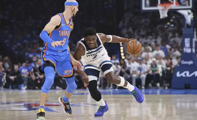Minnesota Timberwolves guard Anthony Edwards (5) works toward the basket as Oklahoma City Thunder guard Alex Caruso (9) defends during the first half of Game 5 of the Western Conference finals of the NBA basketball playoffs, Wednesday, May 28, 2025, in Oklahoma City. (AP Photo/Nate Billings)