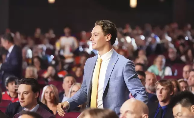 James Hagens walks to the stage after being drafted by the Boston Bruins during the NHL hockey draft Friday, June 27, 2025, in Los Angeles. (AP Photo/Damian Dovarganes)