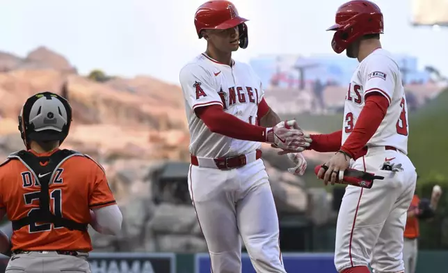Los Angeles Angels Logan O'Hoppe, center, celebrates after his two-run home run with teammate Taylor Ward (3) near Houston Astros catcher Yainer Diaz (21) in the third inning of a baseball game Saturday, June 21, 2025, in Anaheim, Calif. (AP Photo/Wally Skalij)