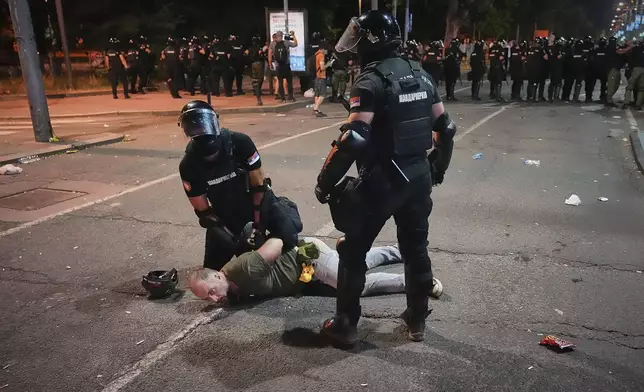 Riot police detain a man after charging protesters at the end of an anti-government rally pressing for an early election after nearly eight months of almost daily anti-corruption demonstrations that have shaken the populist government of President Aleksandar Vucic, in Belgrade, Serbia, Saturday, June 28, 2025. (AP Photo/Darko Vojinovic)