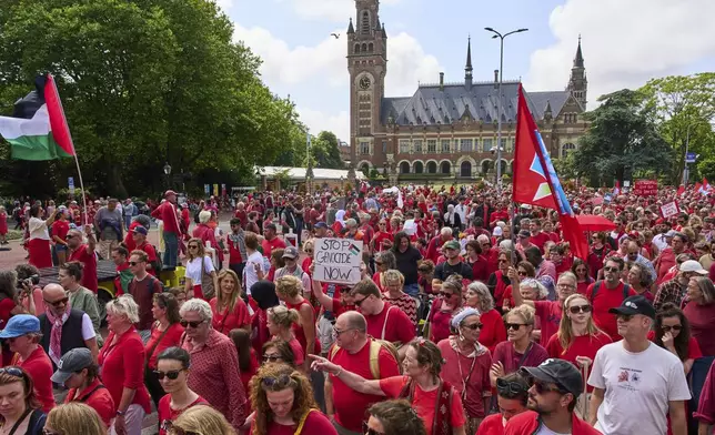 Tens of thousands of red-clad protesters marched past the Peace Palace, housing the International Court of Justice, rear, demanding their government do more to halt Israel's campaign in Gaza, during a demonstration in The Hague, Netherlands, Sunday, June 15, 2025. (AP Photo/Peter Dejong)