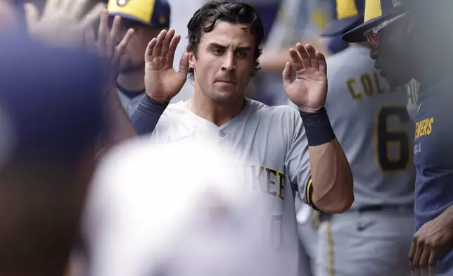 Milwaukee Brewers' Sal Frelick is congratulated after scoring on a throwing error by Minnesota Twins catcher Ryan Jeffers during the first inning of a baseball game, Saturday, June 21, 2025, in Minneapolis. (AP Photo/Bailey Hillesheim)