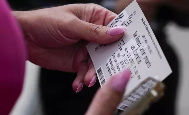 Tara Hoot holds their ticket to Les Miserables at the Kennedy Center, Wednesday, June 11, 2025, in Washington. (AP Photo/Julia Demaree Nikhinson)