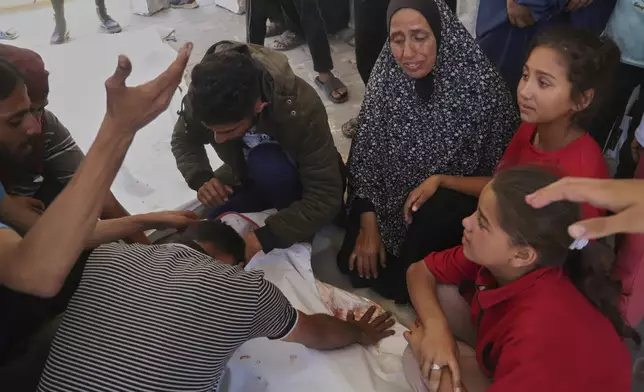 Relatives mourn over the body of Palestinian teenager Ghazal Eyad, 16, who was killed while heading to an aid distribution hub, during her funeral in Rafah, southern Gaza Strip, Wednesday, June 11, 2025. (AP Photo/Mariam Dagga)