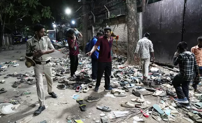 People rummage through footwear strewn outside M. Chinnaswamy Stadium after a stampede caused by frenzied fans celebrating Royal Challengers Bengaluru's victory in the Indian Premier League cricket tournament, in Bengaluru, India, Wednesday, June 4, 2025. (AP Photo/Aijaz Rahi)