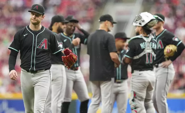 Arizona Diamondbacks' Ryne Nelson, left, reacts as he walks to the dugout following a pitching change in the fourth inning of a baseball game against the Cincinnati Reds, Saturday, June 7, 2025, in Cincinnati. (AP Photo/Jeff Dean)