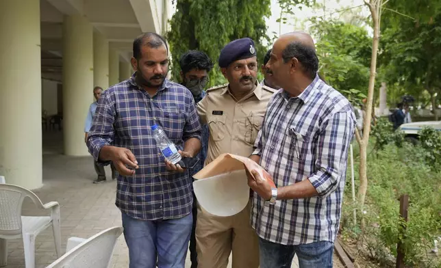 Ratheesh Nair, left, brother of Air India plane crash victim Ranjitha Nair, leaves a hospital after giving his DNA sample to identify his sister's body in Ahmedabad, India, Saturday, June 14, 2025. (AP Photo/Rafiq Maqbool)