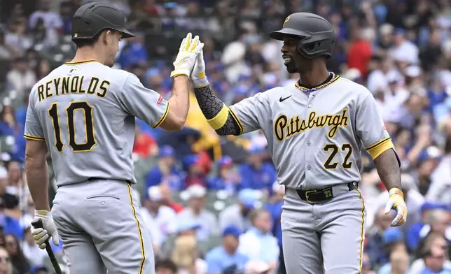Pittsburgh Pirates' Andrew McCutchen (22) high-fives Bryan Reynolds, left, after hitting a home run in the first inning of a baseball game against the Chicago Cubs , Saturday, June 14, 2025, in Chicago. (AP Photo/Matt Marton)