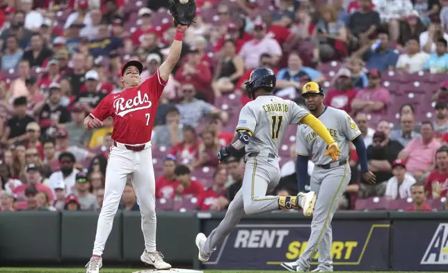 Cincinnati Reds' Spencer Steer reaches to catch a high throw before Milwaukee Brewers' Jackson Chourio can reach first base in the third inning of a baseball game Tuesday, June 3, 2025, in Cincinnati. (AP Photo/Kareem Elgazzar)