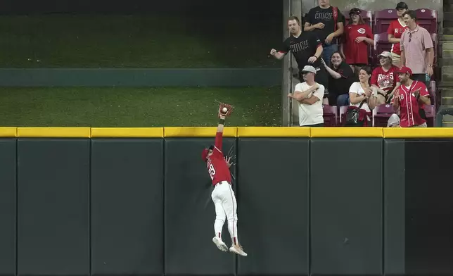 Cincinnati Reds' TJ Friedl catches a fly ball at the wall to end the game in the ninth inning of a baseball game against the Milwaukee Brewers, Tuesday, June 3, 2025, in Cincinnati. (AP Photo/Kareem Elgazzar)